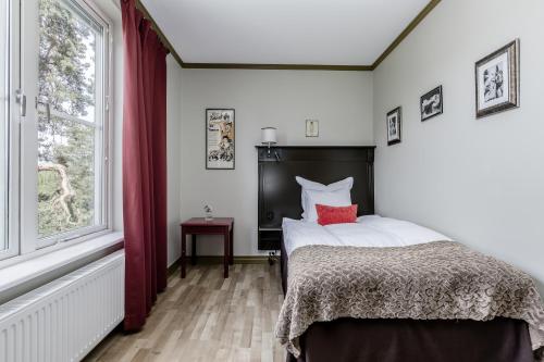 a bedroom with a bed and a window at Såstaholm Hotell & Konferens in Täby