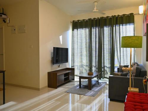 a living room with a couch and a tv at No Fixed Address in Marmagao