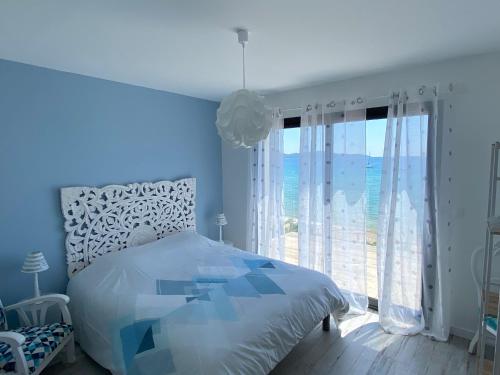 une chambre avec un lit et une grande fenêtre dans l'établissement Villa Récampado Les pieds dans l'eau avec piscine, à Cavalaire-sur-Mer
