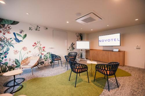 a meeting room with chairs and a podium with a screen at Novotel Le Havre Centre Gare in Le Havre