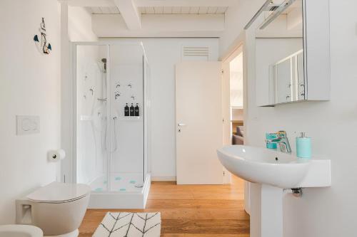 y baño blanco con lavabo y ducha. en Attico Riva Mare, en Muggia