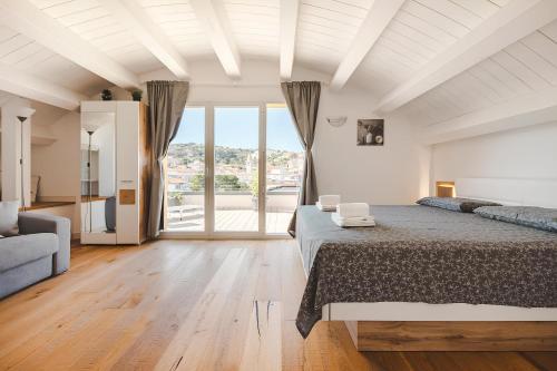 1 dormitorio con cama grande y ventana grande en Attico Riva Mare, en Muggia