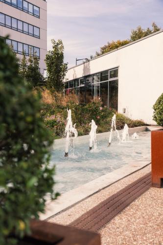 a group of water fountains in front of a building at Novotel Le Havre Centre Gare in Le Havre