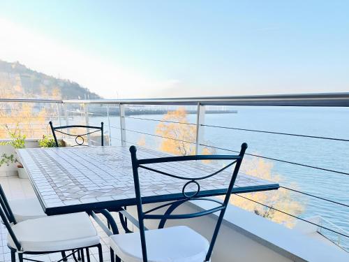 a table and chairs on a balcony with a view of the water at Attico Riva Mare in Muggia