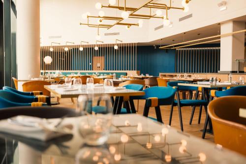 a dining room with tables and chairs at Novotel Le Havre Centre Gare in Le Havre