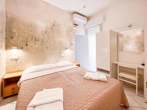 - une chambre avec un lit et 2 serviettes dans l'établissement Hotel Giulio Cesare, à Cattolica