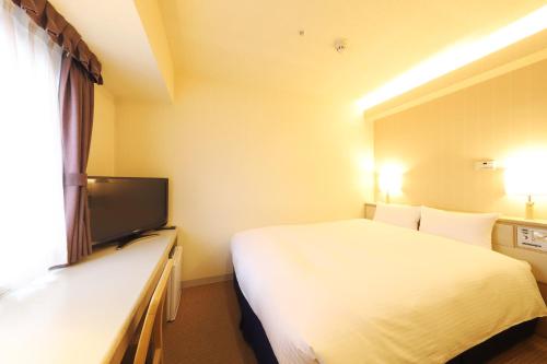 pokój hotelowy z łóżkiem i telewizorem z płaskim ekranem w obiekcie Shin-Yokohama Kokusai Hotel w mieście Jokohama