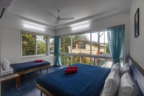 a bedroom with two beds and a large window at Stayscape Casa Santorini 4BHK Lonavala in Oxel
