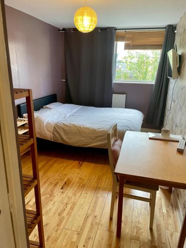 a small room with a bed and a table and a dining table at Heart of West London in London