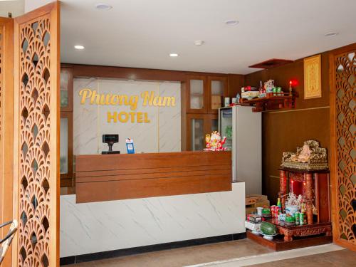 aoking man hotel with a counter in a room at Phuong Nam Luxury Hotel Long Bien in Hanoi