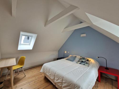 une chambre avec un lit, un bureau et une fenêtre dans l'établissement House in Terenez with Stunning Harbour Views, à Plougasnou