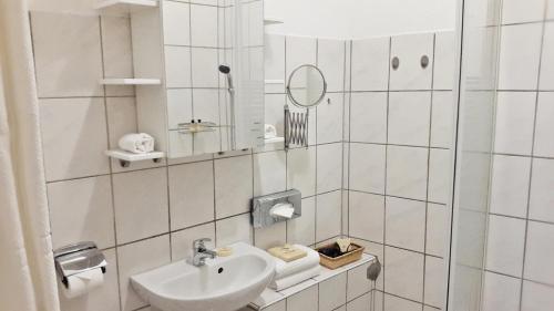 アイゼナハにあるAlte Uhrmacherei Eisenachの白いバスルーム(シンク、鏡付)