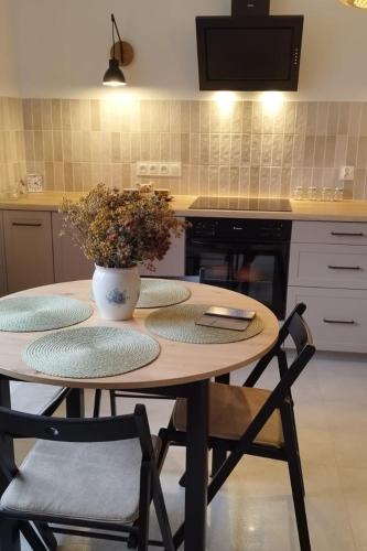 a kitchen with a table with a vase of flowers on it at Pokoje Gościnne "SOSENKA" in Cisna
