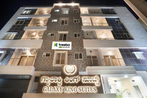 un edificio alto con un cartel delante en Treebo Trend Galaxy Kings Suites - Hebbal, en Bangalore