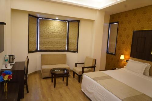 a hotel room with a bed and a chair and a table at Hotel Forest Avenue - Best Luxury Hotel in Dehradun in Dehradun