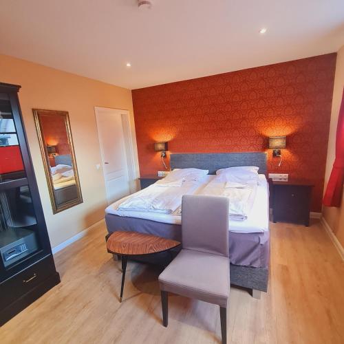 a bedroom with a large bed and a chair at The Cosy Home in Hodenhagen