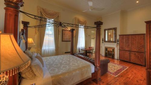 een slaapkamer met een hemelbed en een open haard bij Hermitage Hill Country Retreat in Wellington