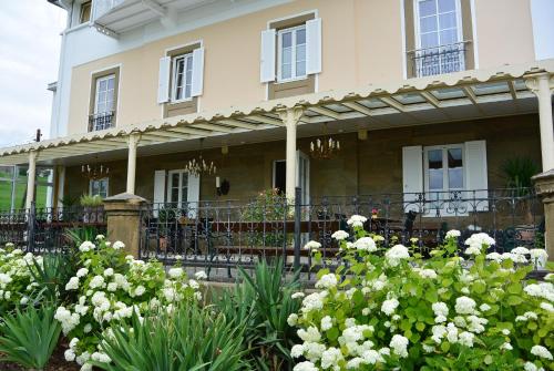 a house with a flower garden in front of it at Villa Thalhof in Bad Gleichenberg