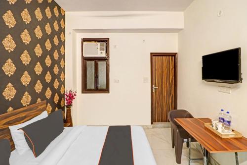 ein Hotelzimmer mit einem Bett und einem Schreibtisch in der Unterkunft OYO Town Plaza in Neu-Delhi