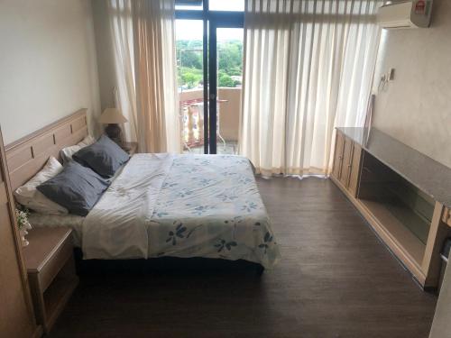 ein Schlafzimmer mit einem Bett und einem großen Fenster in der Unterkunft Nasz Riverbank Suites in Kuching