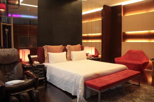 新竹市にあるMadrid Classic Hotelのベッドと赤い椅子のある寝室