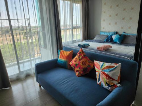 sala de estar con 2 camas y sofá con almohadas en 中央公寓 1bedroom Centrio Condominium, en Ban Rangeng