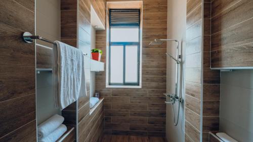 a bathroom with wooden walls and a shower at ROOFTOP VIEW APARTMENTS REBERO in Kigali