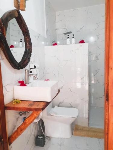 a bathroom with a sink and a toilet at TIANDE Boutique Hotel in Pwani Mchangani