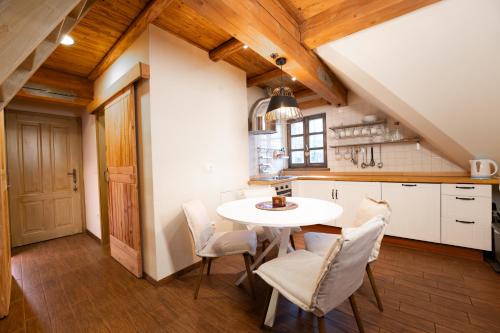a kitchen with a white table and white chairs at Apartments Julijana in Kranjska Gora