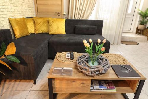 a living room with a black couch and a coffee table at IRIS COZY HOUSE με ανεξάρτητη είσοδο in Volos