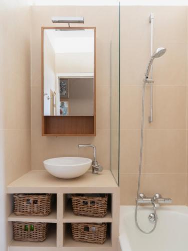 une salle de bain avec un lavabo et un miroir dans l'établissement Paris Eugène Design Residence, à Paris