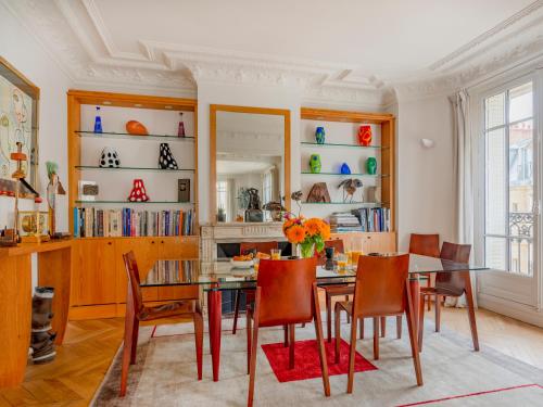 une salle à manger avec une table et des chaises dans l'établissement Paris Eugène Design Residence, à Paris