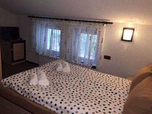 a bedroom with a bed with white shoes on it at Семеен хотел Гингеръ in Pamporovo