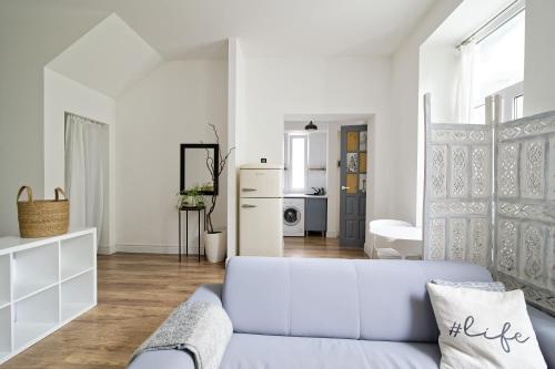 a white living room with a couch and a kitchen at White Door Apartments Heart of Odessa 1 in Odesa