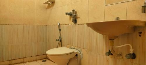 La salle de bains est pourvue d'un lavabo et de toilettes. dans l'établissement HOTEL MANHATTAN, à Chennai