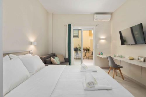 Un dormitorio blanco con una cama y una sala de estar. en Yard Studio by CorfuEscapes, en Corfú