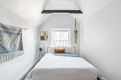 Decompress in the Zen Surroundings of a Cozy Carriage House في واشنطن: غرفة نوم بيضاء بها سرير ونافذة