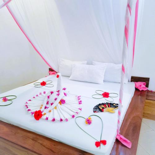 a bed in a tent with flowers on it at TIANDE Boutique Hotel in Pwani Mchangani