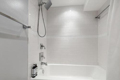 a white bathroom with a shower and a sink at Entire 1-BR Apt in NoMa Eckington in Washington, D.C.