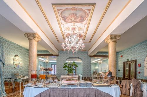a dining room with a table and a chandelier at Hotel Giorgione in Venice