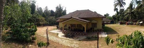 a small yellow house in the middle of a yard at Malnad Bliss in Sringeri