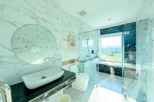 uma casa de banho com um lavatório, um WC e um chuveiro em Marble Arch De Loei Hotel em Loei