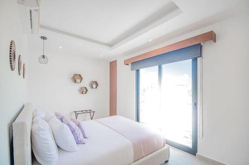 a bedroom with a bed with pillows and a window at Joya de la Zazil 20 Av ROOFTOP POOL Walk to Playa Mamitas Coco Beach & 5 in Playa del Carmen