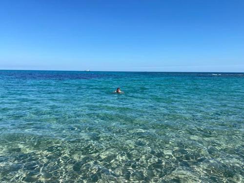 eine Person, die in einem großen Wasserkörper schwimmt in der Unterkunft Sousse Beach luxe in Harqalah