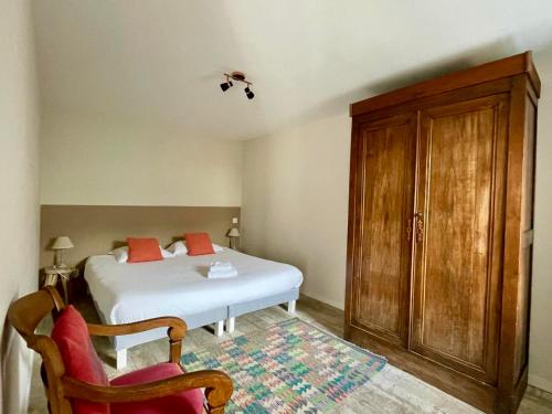 a bedroom with a white bed and a wooden cabinet at Belle location Spa et grande terrasse privés in La Couarde-sur-Mer