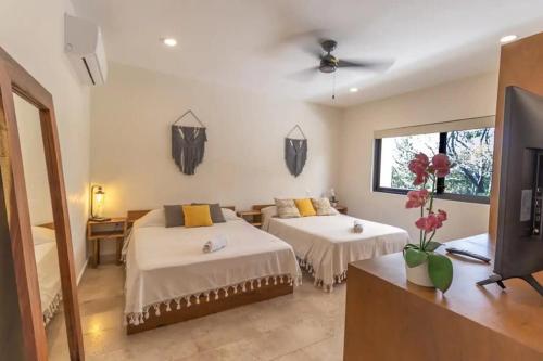 a bedroom with two beds and a tv in it at Maranay 2 Story 3BR Penthouse in La Veleta in Tulum