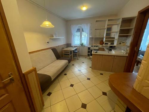een woonkamer met een bank en een keuken bij Platán Apartman in Marcali
