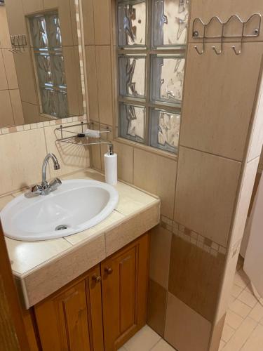 een badkamer met een wastafel en een spiegel bij Platán Apartman in Marcali