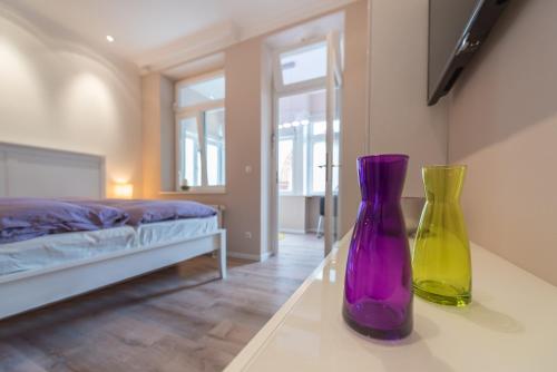 zwei Vasen auf einem Tisch in einem Schlafzimmer in der Unterkunft Ferienwohnung Pusteblume - Villa Stranddistel in Binz