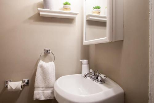 a bathroom with a sink and a mirror and a towel at IDEAL GEORGETOWN STAY \ PARKING! \ W/D in Washington, D.C.